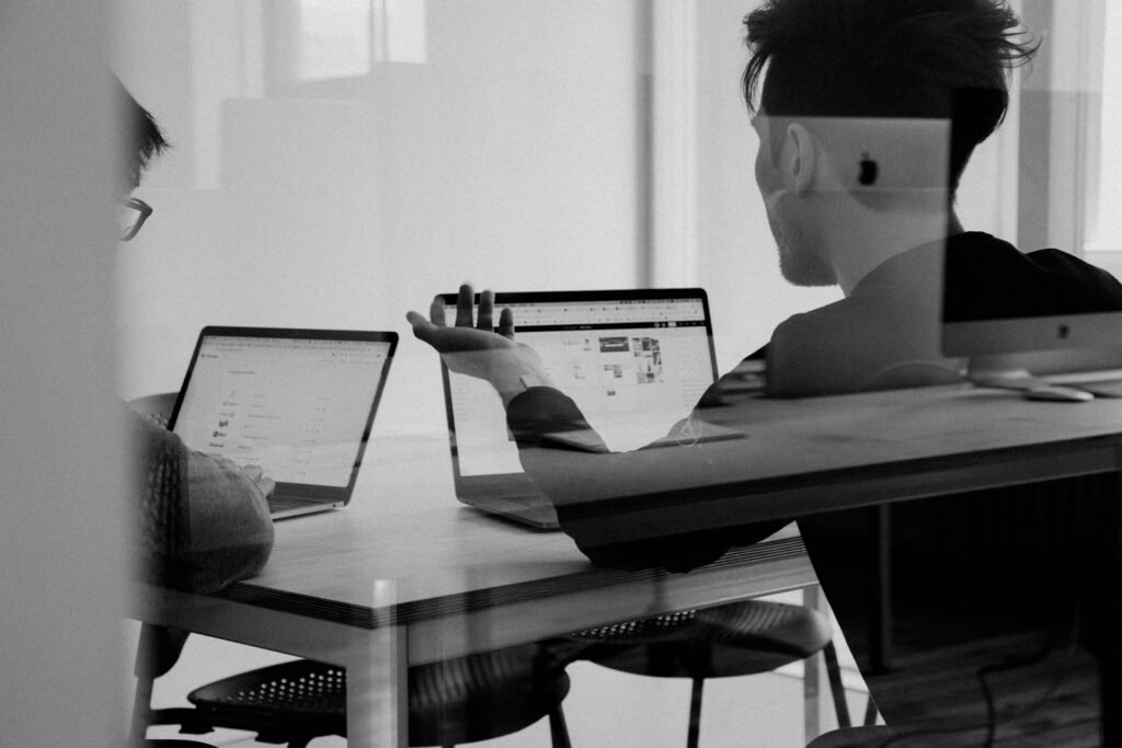 Team members talking around a laptop, representing customer conversations