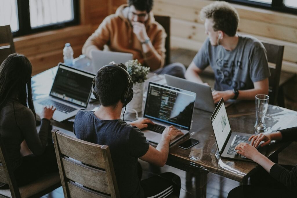 People working together at a table with laptops and notes