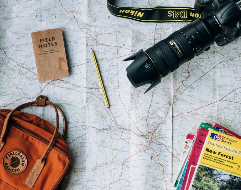 A traveler planning a trip with a map, camera, and passport on a table